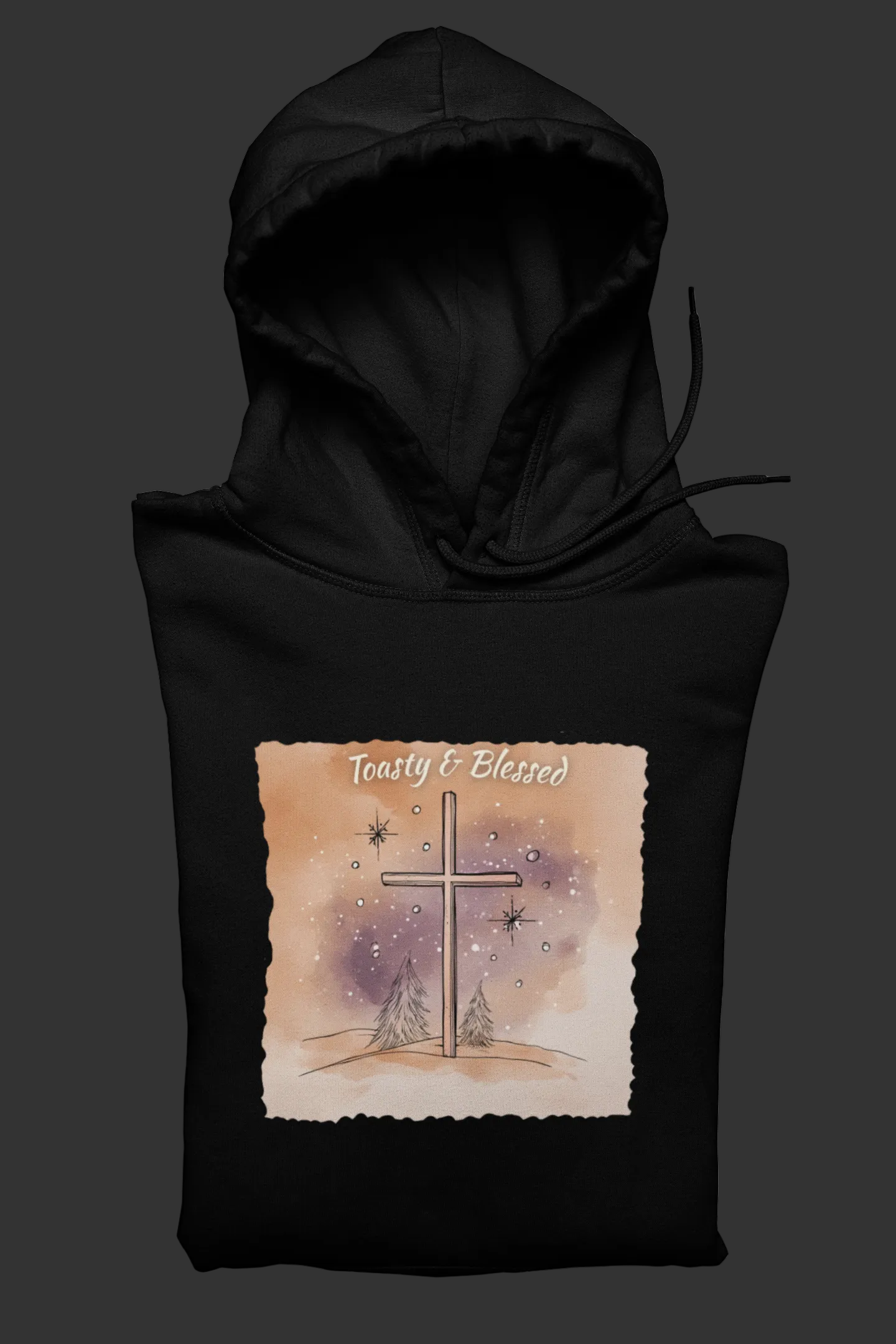 Black hoodie with a watercolor cross design and 'Toasty & Blessed' text on a white background