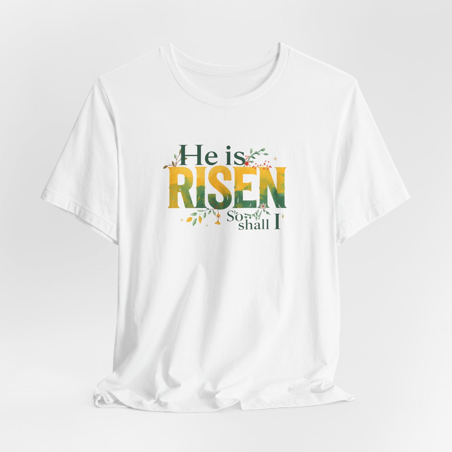 White t-shirt with 'He is Risen, So Shall I' text on a light gray background
